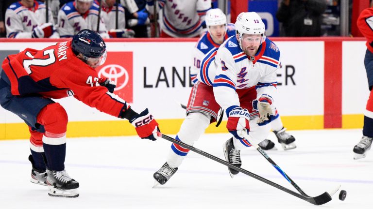 New York Rangers left wing Alexis Lafrenière (13) battles for the puck against Washington Capitals defenceman Martin Fehérváry (42) during the second period of an NHL hockey game, Tuesday, Dec. 23, 2025, in Washington. (Nick Wass/AP)