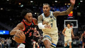 Toronto Raptors' Immanuel Quickley (5) drives to the basket against Milwaukee Bucks' Kevin Porter Jr. (7) during the first half of an NBA basketball game Thursday, Dec. 18, 2025, in Milwaukee. (AP Photo/Aaron Gash)