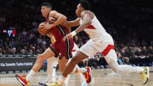 Miami Heat Simone Fontecchio, left, drives to the basket as Toronto Raptors forward Scottie Barnes, right, defends during the first half of an NBA basketball game, Tuesday, Dec. 23, 2025, in Miami. (AP Photo/Lynne Sladky)