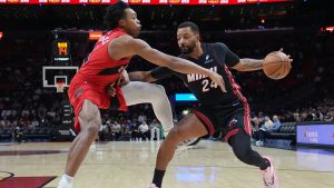 Miami Heat guard Norman Powell (24) drives to the basket as Toronto Raptors forward Scottie Barnes, left, defends during the first half of an NBA basketball game, Monday, Dec. 15, 2025, in Miami. (AP Photo/Lynne Sladky)