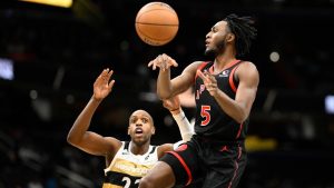 Toronto Raptors guard Immanuel Quickley (5) passes the ball against Washington Wizards forward Khris Middleton (22) during the first half of an NBA basketball game, Friday, Dec. 26, 2025, in Washington. (AP Photo/Nick Wass)