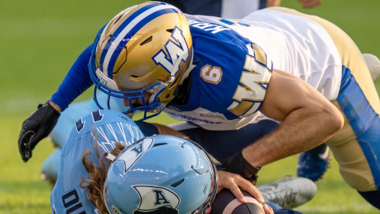 Toronto Argonauts quarterback Cameron Dukes (11) is sacked by Winnipeg Blue Bombers defensive back Redha Kramdi (6) during first half CFL football action in Toronto on Saturday, July 27, 2024. (Frank Gunn/CP)