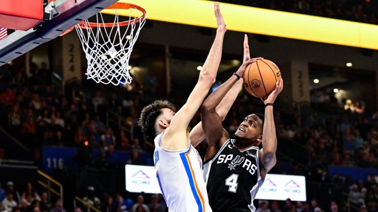 San Antonio Spurs guard De'Aaron Fox (4) shoots against Oklahoma City Thunder Chet Holmgren (7) during the first half of an NBA basketball game, Thursday, Dec. 25, 2025, in Oklahoma City. (AP Photo/Gerald Leong)