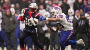 New England Patriots running back Rhamondre Stevenson, left, runs against Buffalo Bills outside linebacker Matt Milano during the first half of an NFL football game in Foxborough, Mass., Sunday, Dec. 14, 2025. (Charles Krupa/AP)