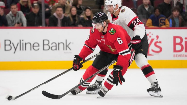 Chicago Blackhawks defenceman Sam Rinzel (6), left, and Ottawa Senators centre Dylan Cozens (24) fight for control of the puck during the second period of an NHL hockey game Tuesday, Oct. 28, 2025, in Chicago. (Erin Hooley/AP)