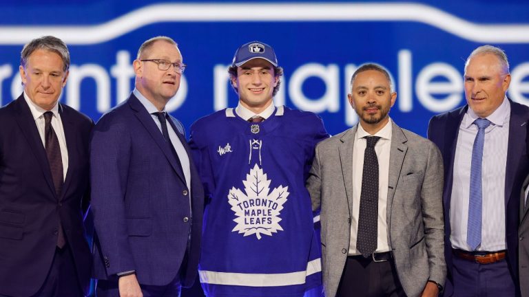 Ben Danford, centre, poses after being selected by the Toronto Maple Leafs during the first round of the NHL hockey draft Friday, June 28, 2024, in Las Vegas. (Steve Marcus/AP)