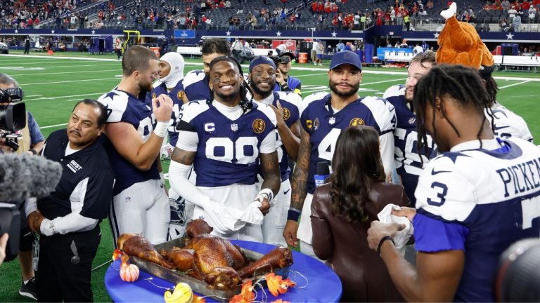 Dallas Cowboys offensive players including Dak Prescott (4) CeeDee Lamb (88) George Pickens (3) Jake Ferguson (87) and CBS reporter Tracy Wolfson with the post game turkey leg ceremony after the Thanksgiving day NFL football game against the Kansas City Chiefs on Thursday, Nov. 27, 2025, in Arlington, Texas. (Matt Patterson/AP)