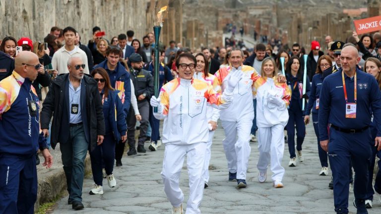 Actor Jackie Chan holds the Olympic torch passing through the Archaeological Park in Pompeii, Italy, Monday, Dec. 22, 2025. (Alessandro Garofalo/LaPresseAP)