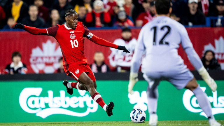 Canada's Jonathan David shoots on net while Australia goalkeeper Paul Izzo defends during first-half international friendly soccer action, in Montreal, on Friday, October 10, 2025. (Christopher Katsarov/CP)