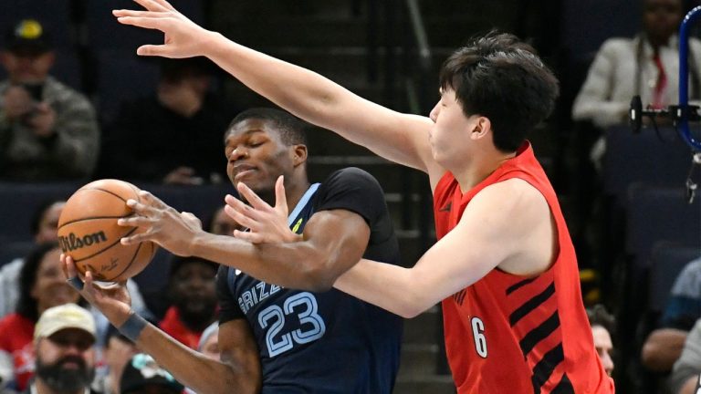 Memphis Grizzlies forward Cedric Coward (23) handles the ball against Portland Trail Blazers center Yang Hansen (16) in the first half of an NBA basketball game Sunday, Dec. 7, 2025, in Memphis, Tenn. (Brandon Dill/AP)