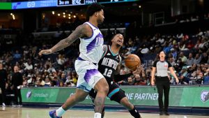 Memphis Grizzlies guard Ja Morant (12) handles the ball against Utah Jazz forward Brice Sensabaugh, left, in the second half of an NBA basketball game Friday, Dec. 12, 2025, in Memphis, Tenn. (Brandon Dill/AP)