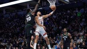 Phoenix Suns forward Dillon Brooks (3) shoots while defended by Minnesota Timberwolves forward Julius Randle (30) during the second half of an NBA basketball game, Monday, Dec. 8, 2025, in Minneapolis. (Abbie Parr/AP)