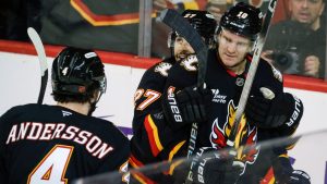 Calgary Flames' Jonathan Huberdeau, right, celebrates his goal with teammates during second period NHL hockey action against the Minnesota Wild in Calgary on Thursday, Dec. 4, 2025.(Jeff McIntosh/THE CANADIAN PRESS)