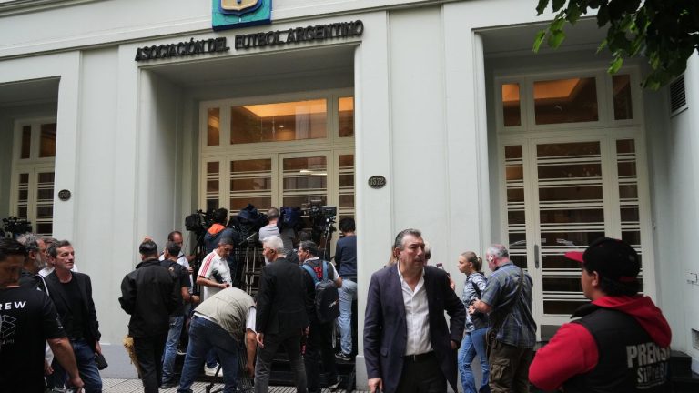 Journalists gather outside the Argentine Soccer Association headquarters being raided as part of a judicial investigation into alleged money laundering in Buenos Aires, Argentina, Tuesday, Dec. 9, 2025. (AP Photo/Rodrigo Abd)
