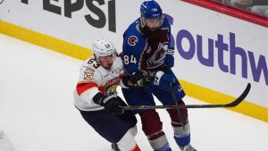 Florida Panthers left wing Brad Marchand, left, pursues the puck with Colorado Avalanche defenceman Brent Burns in the first period Thursday, Dec. 11, 2025, in Denver. (AP Photo/David Zalubowski)