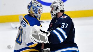St. Louis Blues goaltender Jordan Binnington (50) shakes hands with Winnipeg Jets goaltender Connor Hellebuyck (37) after the Jets won in the second overtime period of NHL round one, game seven Stanley Cup playoff action in Winnipeg, Sunday May 4, 2025. (Fred Greenslade/THE CANADIAN PRESS)
