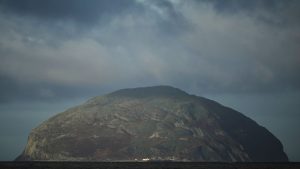 The island of Ailsa Craig, where the two types of granite, Common Green and Blue Hone, that are used to make curling stones is quarried from, is seen from the beach at Girvan, Scotland, Thursday, Nov. 13, 2025. (Alastair Grant/AP)