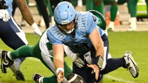 Toronto Argonauts quarterback Nick Arbuckle (4) recovers a fumbled ball and is tackled by Saskatchewan Roughriders Caleb Sanders during second half CFL football action in Toronto Friday, June 20, 2025. (Jon Blacker/THE CANADIAN PRESS)