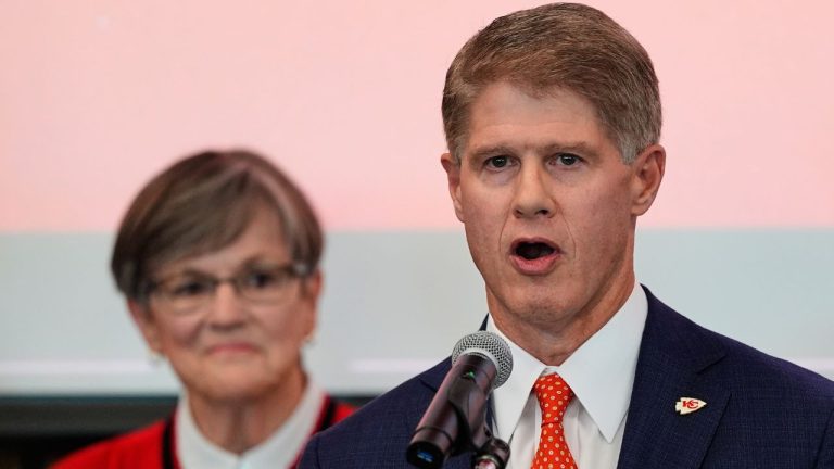Kansas City Chiefs owner Clark Hunt, right, addresses attendees while Kansas Gov. Laura Kelly, left, looks on during an event Monday, Dec. 22, 2025, in Topeka, Kan., announcing the team will leave Arrowhead Stadium in Kansas City, Mo. for a new stadium that will be built across the Kansas-Missouri state line and be ready for the start of the 2031 season. (Charlie Riedel/AP)