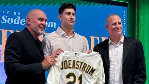Tyler Soderstrom, centre, during a news conference joined by manager Mark Kotsay, left, and General Manager David Forst at the A's Ballpark Experience Center in Las Vegas, Nev. on Tuesday, Dec. 30, 2025. (AP Photo/Mark Anderson)