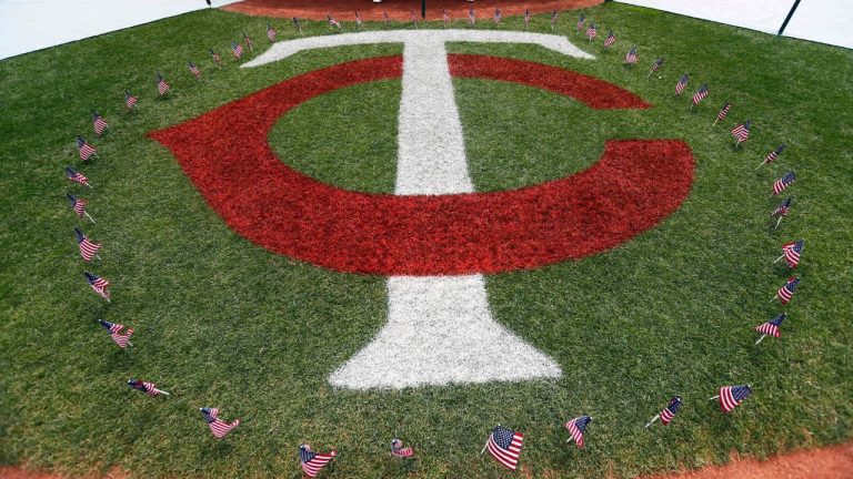 Flags marking the Fourth of July holiday surround the Minnesota Twins logo prior to a baseball game against the Oakland Athletics, Monday, July 4, 2016, in Minneapolis. (AP Photo/Jim Mone)