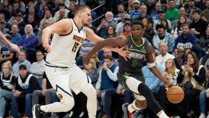 Minnesota Timberwolves guard Anthony Edwards (5) works toward the basket as Denver Nuggets centre Nikola Jokic (15) defends during the second half of an NBA basketball game, Friday, Nov. 1, 2024, in Minneapolis. (Abbie Parr/AP)