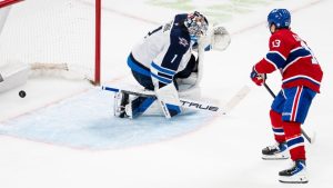 Montreal Canadiens' Cole Caufield scores on Winnipeg Jets goaltender Eric Comrie during NHL hockey overtime shootout action, in Montreal on Wednesday, Dec. 3, 2025. (CP/Christopher Katsarov)