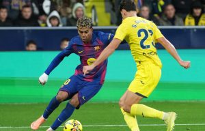 Barcelona's Lamine Yamal, left, duels for the balls with Villarreal's Sergi Cardona during the Spanish La Liga match between Villarreal and Barcelona in Villarreal, Spain, Sunday, Dec. 21, 2025. (AP/Alberto Saiz)