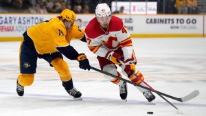 Calgary Flames center Connor Zary (47) moves the puck against Nashville Predators center Tyson Jost (17) during the first period of an NHL game Tuesday, Dec. 2, 2025, in Nashville, Tenn. (Mark Humphrey/AP)