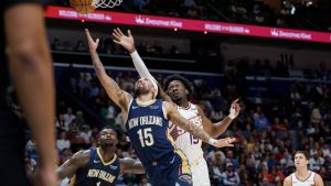 New Orleans Pelicans guard Jose Alvarado (15), centre front, shoots against Phoenix Suns centre Mark Williams (15) during the first half of an NBA basketball game in New Orleans, Saturday, Dec. 27, 2025. (Matthew Hinton/AP)
