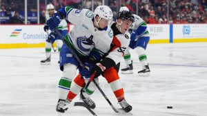 Vancouver Canucks' Marco Rossi, front, and Philadelphia Flyers' Denver Barkey, right, battle for the puck during the second period of an NHL hockey game, Monday, Dec. 22, 2025, in Philadelphia. (Derik Hamilton/AP)