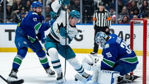 Vancouver Canucks goaltender Thatcher Demko (35) stops San Jose Sharks' Macklin Celebrini (71) as Vancouver's Filip Hronek (17) defends during the first period of an NHL game in Vancouver, B.C., Saturday, Dec. 27, 2025. (Ethan Cairns/CP)