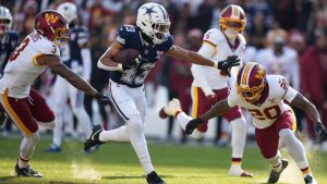 Dallas Cowboys running back Malik Davis (43) runs with the ball as Washington Commanders safety Quan Martin (20) and safety Will Harris (3) defend during the first half an NFL football game Thursday, Dec. 25, 2025, in Landover, Md. (Stephanie Scarbrough/AP Photo)