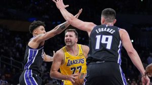 Los Angeles Lakers guard Luka Doncic (77) is defended by Sacramento Kings forward/centre Drew Eubanks (19) and guard Nique Clifford during the first half of a preseason NBA basketball game Friday, Oct. 17, 2025, in Los Angeles. (Jae C. Hong/AP)