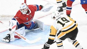Montreal Canadiens goaltender Jacob Fowler (32) makes a save against Pittsburgh Penguins' Connor Dewar (19) during second period NHL hockey action in Montreal, Saturday, Dec. 20, 2025. (Graham Hughes/CP)