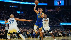 Golden State Warriors guard Stephen Curry (30) shoots between Minnesota Timberwolves center Rudy Gobert (27) and forward Jaden McDaniels (3) during the first half of an NBA basketball game, Friday, Dec. 12, 2025, in San Francisco. (Godofredo A. Vásquez/AP)