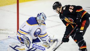 Buffalo Sabres' goalie Ukko-Pekka Luukkonen, left, blocks the net on Calgary Flames' Adam Klapka during first period NHL hockey action in Calgary, Alta., Monday, Dec. 8, 2025. (Jeff McIntosh/CP)