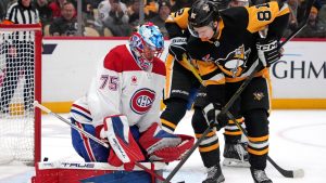 Montréal Canadiens goaltender Jakub Dobes (75) blocks a shot by Pittsburgh Penguins' Ben Kindel, right, during the second period of an NHL hockey game in Pittsburgh, Sunday, Dec. 21, 2025. (Gene J. Puskar/AP)