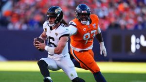 Jacksonville Jaguars quarterback Trevor Lawrence, left, runs against Denver Broncos defensive tackle D.J. Jones during the first half of an NFL football game in Denver, Sunday, Dec. 21, 2025. (Jack Dempsey/AP)