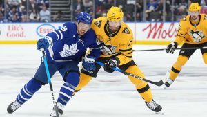 Toronto Maple Leafs forward Nicholas Robertson (89) battles for the puck with Pittsburgh Penguins defenceman Brett Kulak (77) during second period NHL hockey action in Toronto on Tuesday, Dec. 23, 2025. (Nathan Denette/CP)
