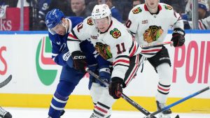 Toronto Maple Leafs forward John Tavares (91) and Chicago Blackhawks forward Oliver Moore (11) vie for control of the puck during first period NHL hockey action in Toronto, Tuesday, Dec. 16, 2025. (Nathan Denette/CP)