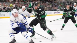 Toronto Maple Leafs defenceman Jake McCabe (22) and Dallas Stars center Roope Hintz (24) skate for the puck during the first period of an NHL hockey game Sunday, Dec. 21, 2025, in Dallas. (LM Otero/AP)