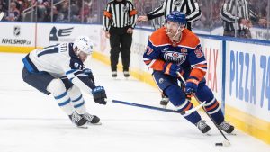 Winnipeg Jets' Cole Perfetti (91) chases Edmonton Oilers' Connor McDavid (97) during second period NHL action in Edmonton on Thursday, March 20, 2025. (Jason Franson/CP)