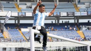 A fan rides a goal post as he protests with others after failing to get a glimpse of Argentine soccer star Lionel Messi at the Salt Lake Stadium, in Kolkata, India, Saturday, Dec. 13, 2025. (Bikas Das/AP)