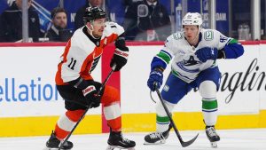 Philadelphia Flyers' Travis Konecny, left, skates the puck past Vancouver Canucks' Marco Rossi during the first period of an NHL hockey game, Monday, Dec. 22, 2025, in Philadelphia. (Derik Hamilton/AP)