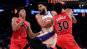 New York Knicks centre Karl-Anthony Towns drives past Toronto Raptors forward Scottie Barnes (4) and Toronto Raptors guard Ochai Agbaji (30) during the second half of an NBA basketball game Sunday, Nov. 30, 2025, in New York. (Yuki Iwamura/AP)