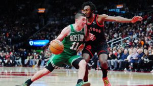Boston Celtics' Payton Pritchard (11) drives past Toronto Raptors' Immanuel Quickley (5) during second half NBA basketball action in Toronto on Saturday, Dec. 20, 2025. (Frank Gunn/CP)