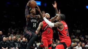 Brooklyn Nets guard Terance Mann (14) looks to pass the ball away from Toronto Raptors guard Jamal Shead, right, and forward Brandon Ingram (3) during the second half of an NBA basketball game, Sunday, Dec. 21, 2025, in New York. (Yuki Iwamura/AP)