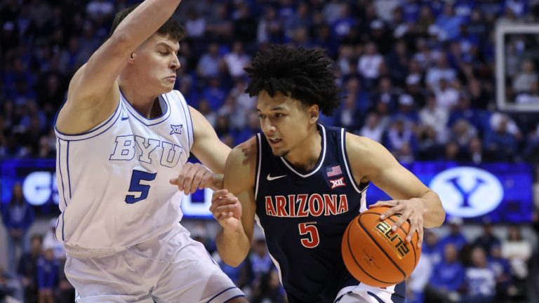 Arizona guard Brayden Burries, right, moves the ball as BYU forward Mihailo Boskovic (5) defends during the second half of an NCAA college basketball game, Monday, Jan. 26, 2026, in Provo, Utah. (AP Photo/Rob Gray)