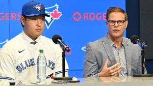 Kazuma Okamoto, left, the Toronto Blue Jays' newest signing, sits with team general manager Ross Atkins at an introductory press conference at Rogers Centre in Toronto on Tuesday, Jan. 6, 2026. (Jon Blacker/CP)